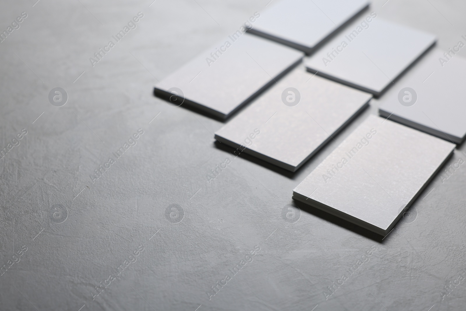 Photo of Blank business cards on light grey textured table, closeup. Mockup for design