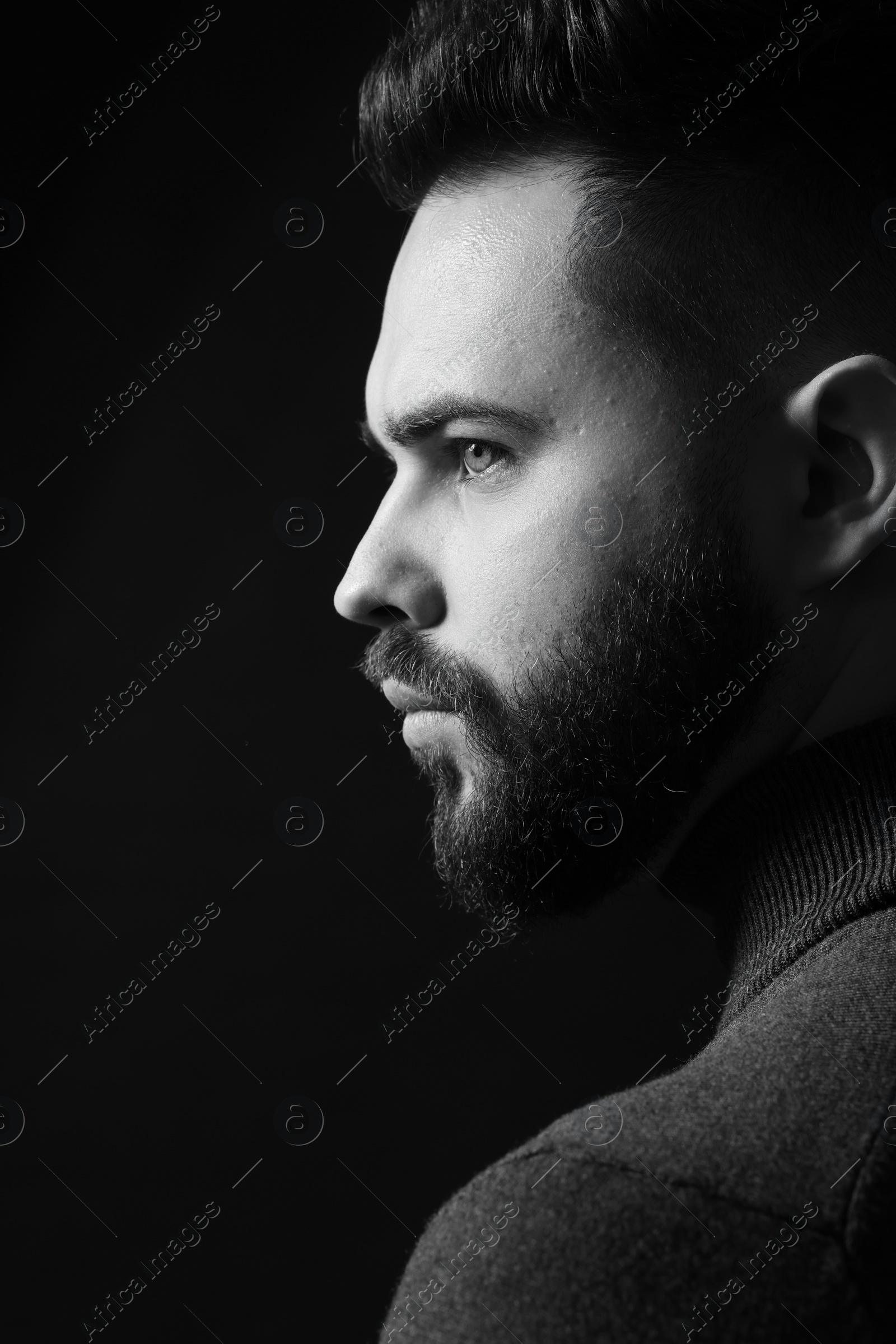 Photo of Portrait of handsome bearded man on dark background. Black and white effect