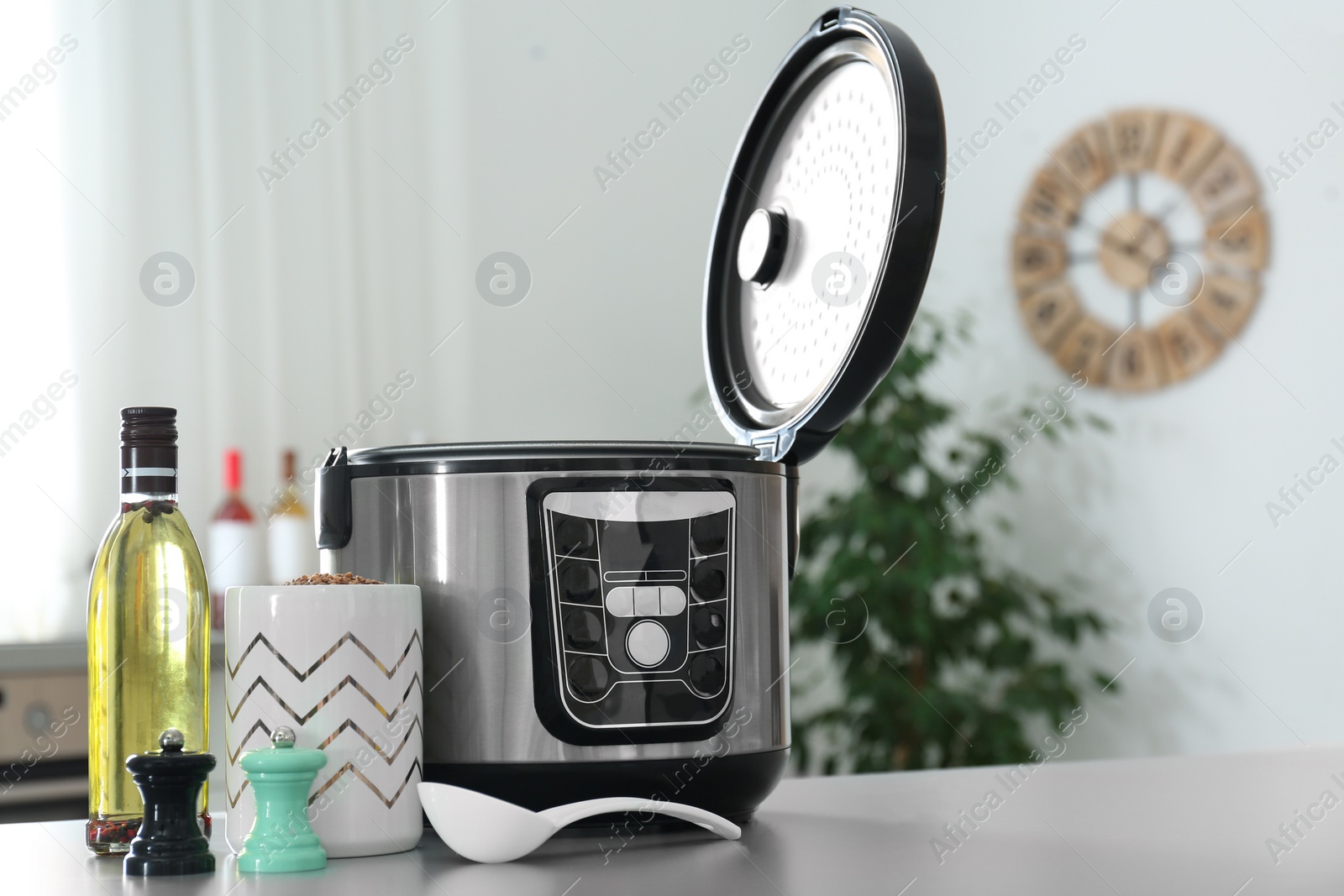 Photo of Modern multi cooker and ingredients on table in kitchen. Space for text