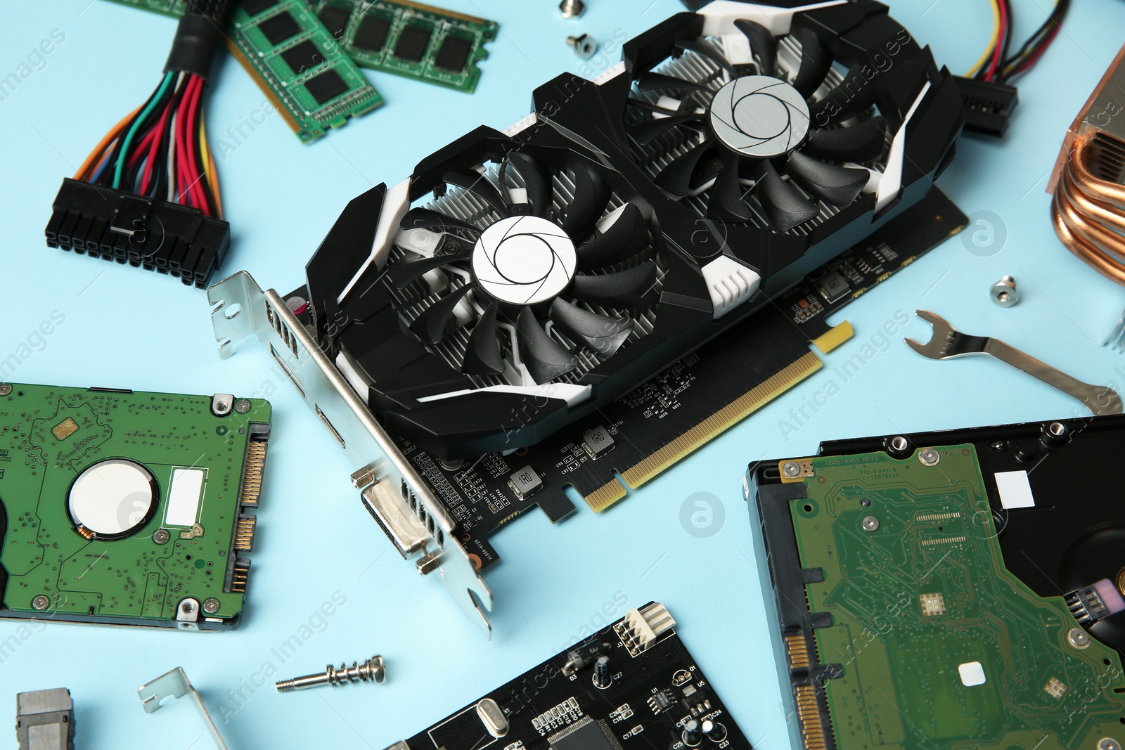 Photo of Graphics card and other computer hardware on light blue background, flat lay