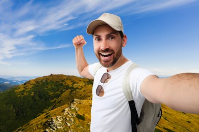 Image of Smiling man taking selfie in beautiful mountains