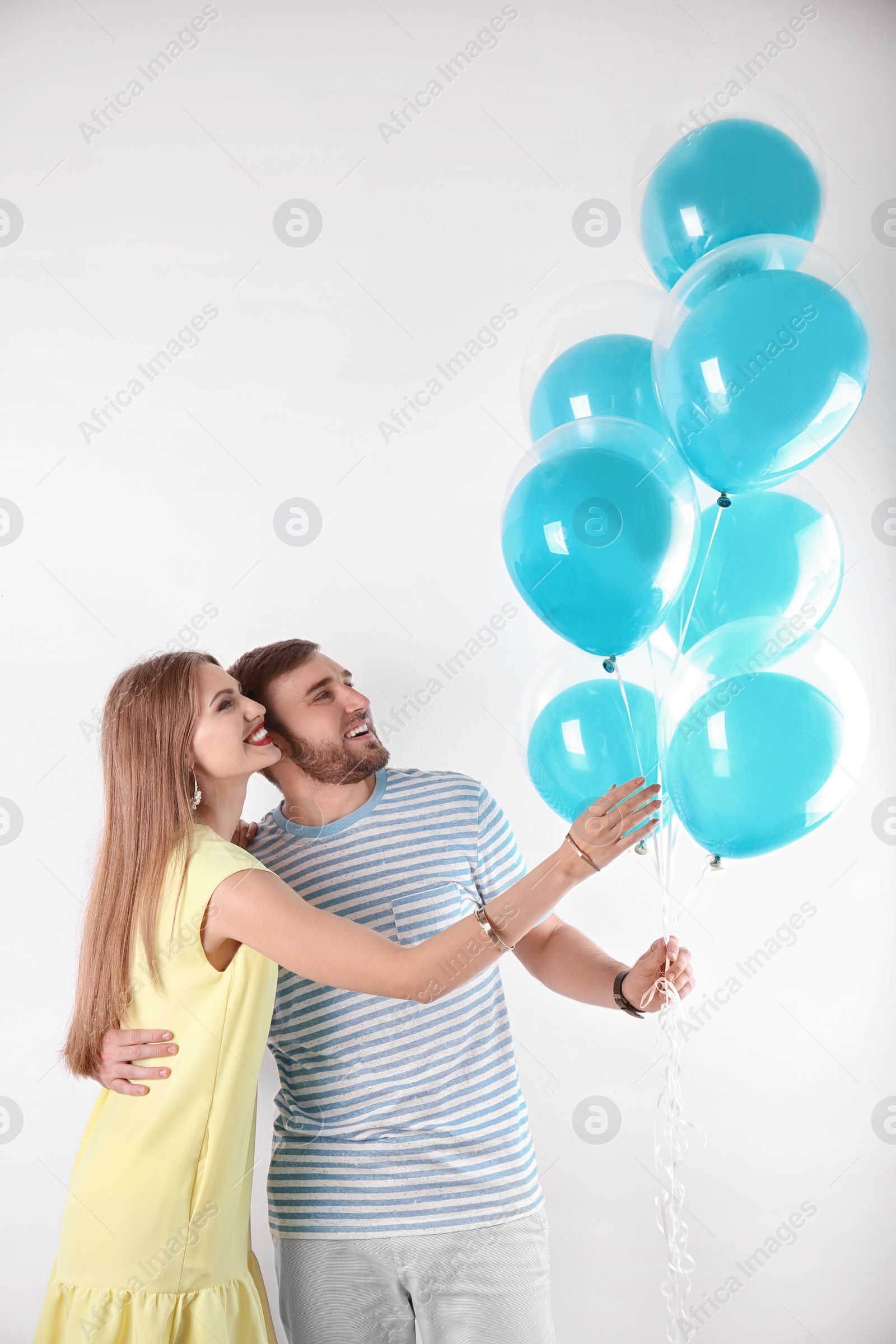 Photo of Young couple with air balloons on white background