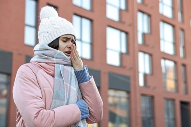 Photo of Sick woman coughing outdoors, space for text. Cold symptom