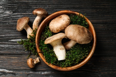 Photo of Flat lay composition with fresh wild mushrooms on black wooden table