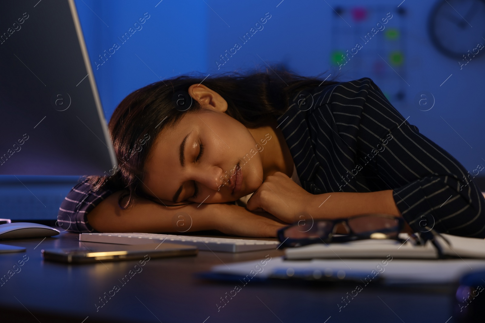 Photo of Tired overworked businesswoman napping at night in office