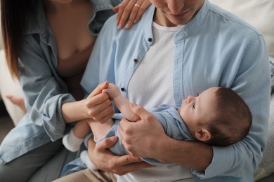 Photo of Young family with cute baby at home, closeup