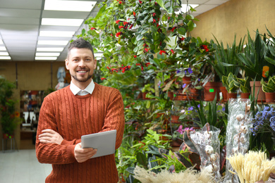 Male business owner with tablet in his flower shop