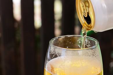 Photo of Pouring beer from can into glass, closeup. Space for text