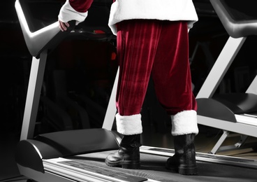 Photo of Authentic Santa Claus training on treadmill in modern gym, closeup