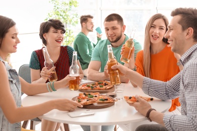 Photo of Young people having fun party with delicious pizza indoors