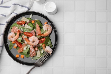 Delicious salad with pomelo, shrimps and tomatoes on white tiled table, flat lay. Space for text