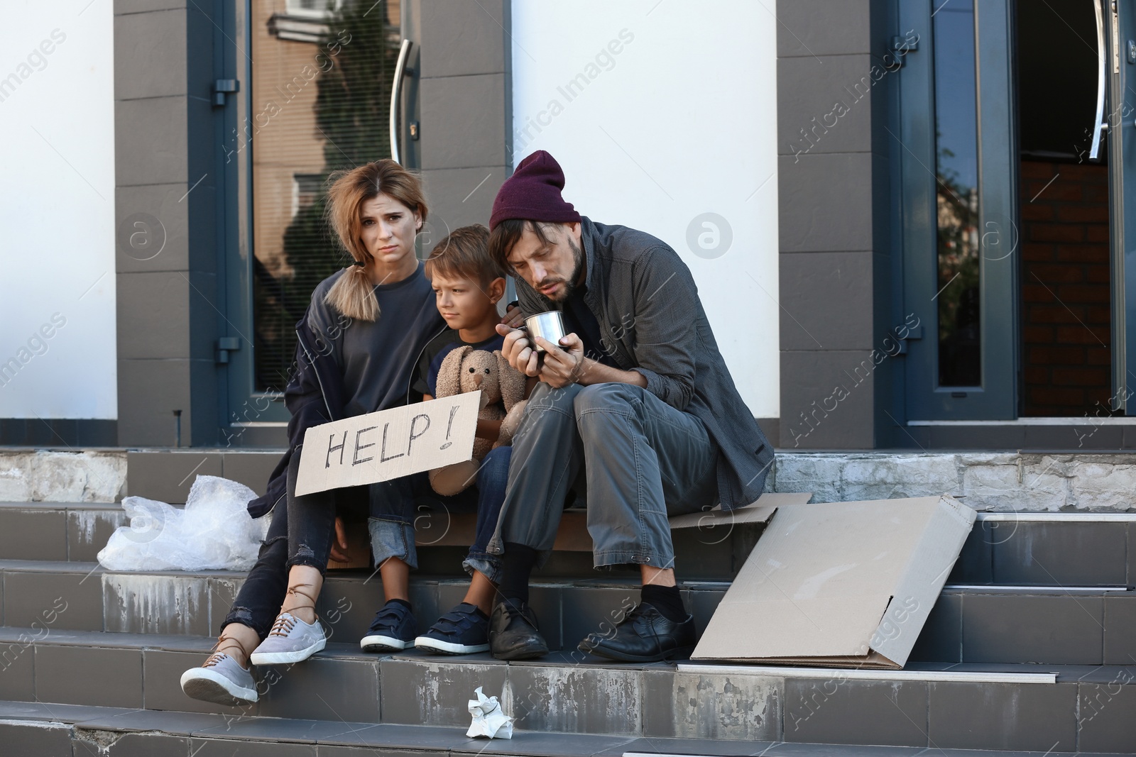 Photo of Poor homeless family begging and asking for help on city street