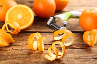 Photo of Orange fruits with peels on white wooden table