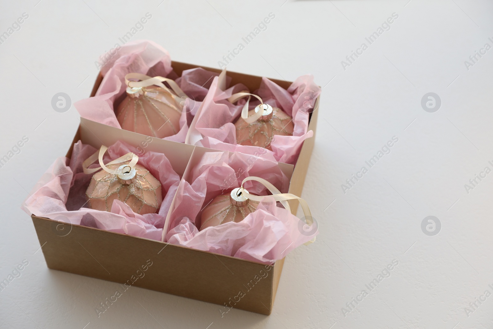 Photo of Beautiful Christmas baubles in box on white background. Space for text