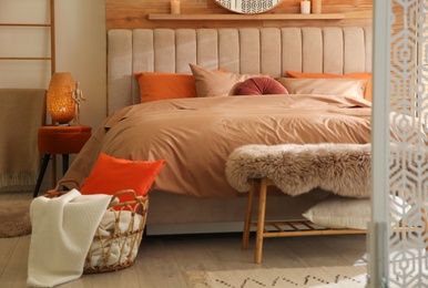 Photo of Bed with brown linens in cozy bedroom. Interior design