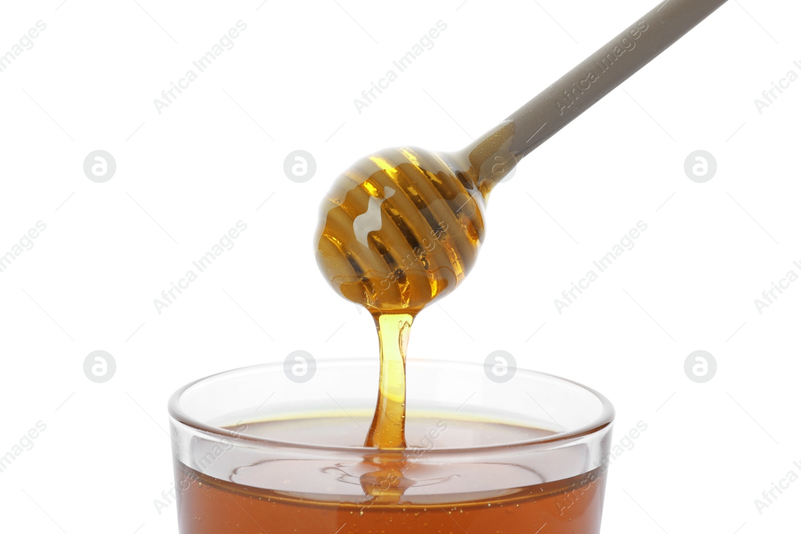 Photo of Honey dripping from dipper into jar on white background