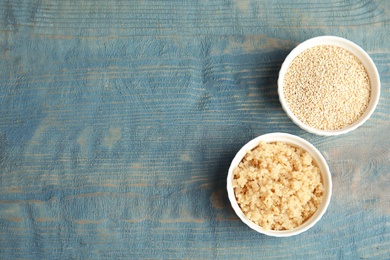 Composition with raw and cooked quinoa in bowls on table, top view. Space for text