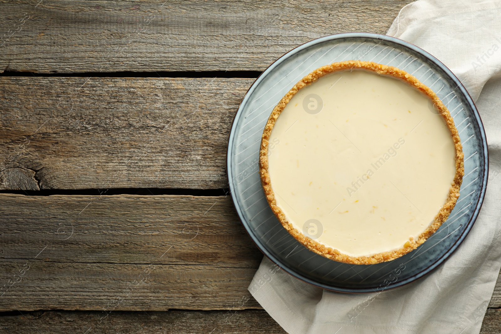 Photo of Tasty vegan tofu cheesecake on wooden table, top view. Space for text