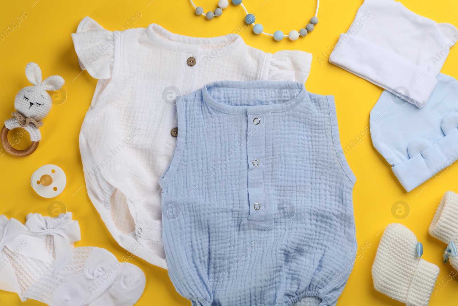 Photo of Flat lay composition with baby clothes and accessories on yellow background