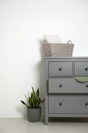 Photo of Grey chest of drawers near light wall