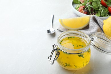 Jar with lemon sauce on light table, space for text. Delicious salad dressing