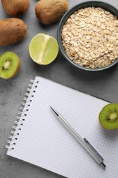 Photo of Healthy diet. Notebook, pen and products on grey table, flat lay