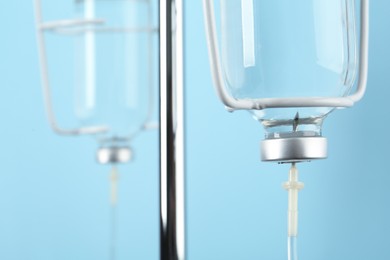 Photo of IV infusion set on light blue background, closeup view