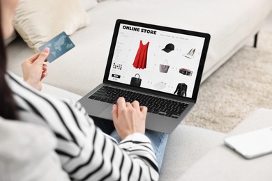 Photo of Woman with credit card using laptop for shopping online indoors, closeup