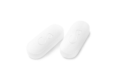 Photo of Two calcium supplement pills on white background