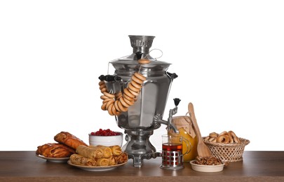 Photo of Traditional Russian samovar with treats on wooden table against white background