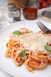 Photo of Delicious pasta with tomato sauce, chicken and parmesan cheese on white table, closeup