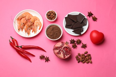 Natural aphrodisiac. Different products and heart model on pink background, flat lay