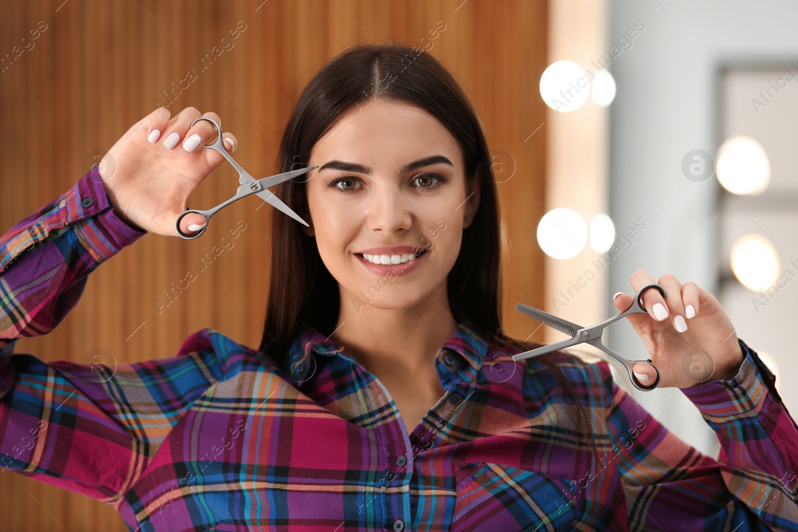 Photo of Hairstylist holding professional scissors in beauty salon