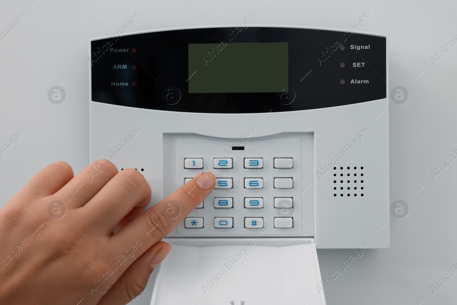 Photo of Woman entering code on home security system indoors, closeup