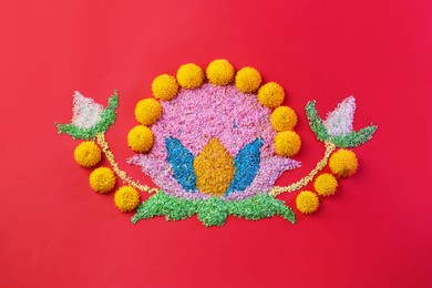 Photo of Happy Diwali. Composition with colorful rangoli and chrysanthemum flowers on red background, top view