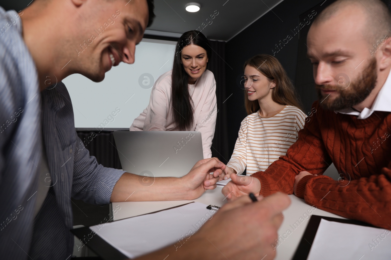 Photo of Business people having meeting in conference room with video projection screen