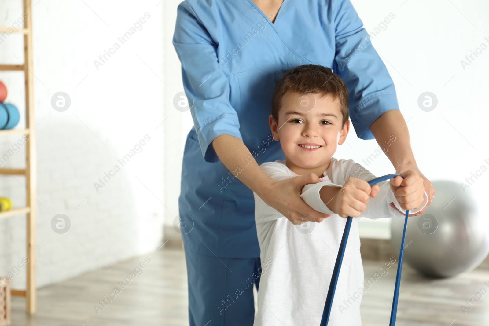 Photo of Orthopedist working with little boy in hospital gym