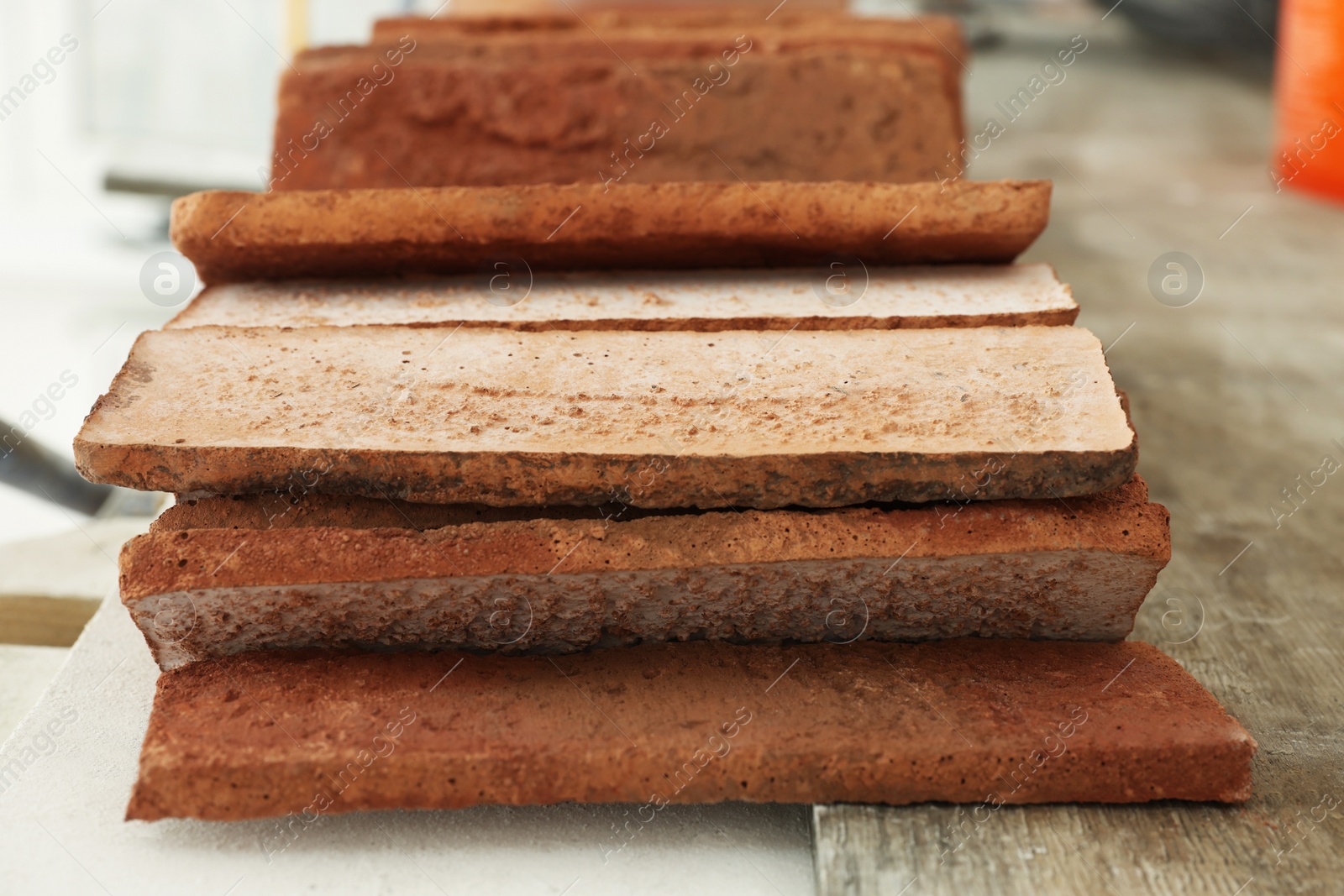 Photo of Many decorative bricks on scaffolding, closeup. Tiles installation process