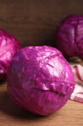 Photo of Whole ripe red cabbages on wooden table