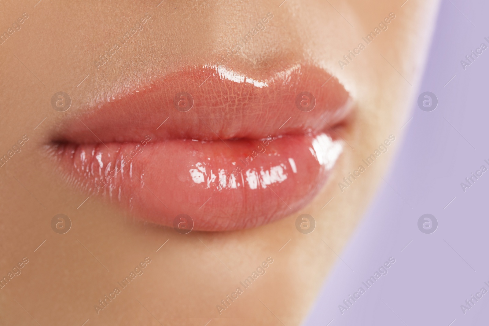 Photo of Young woman with beautiful full lips on lilac background, closeup