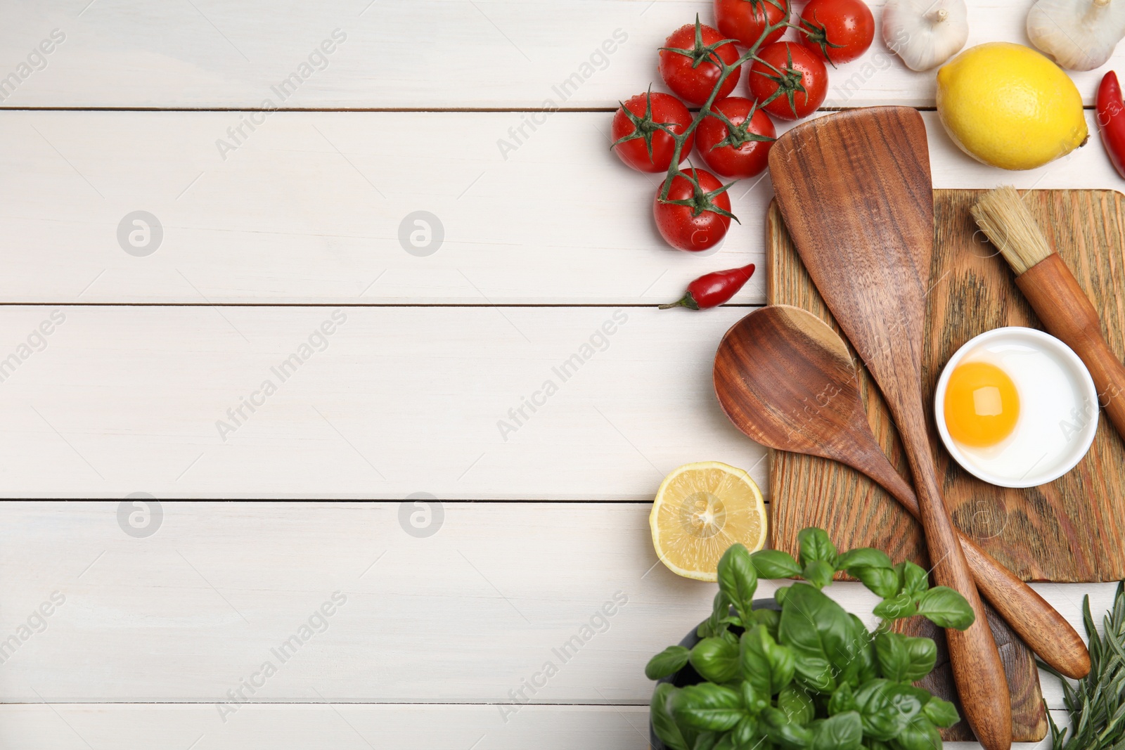 Photo of Flat lay composition with cooking utensils and fresh ingredients on white wooden table. Space for text