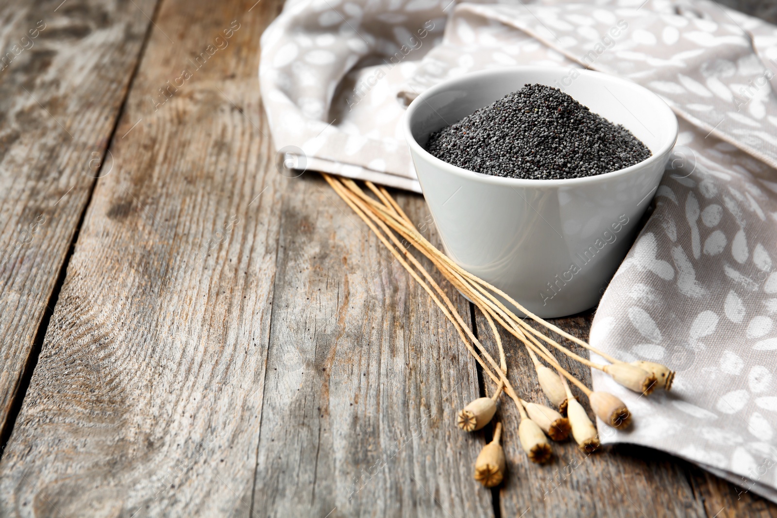 Photo of Composition with poppy seeds on wooden table