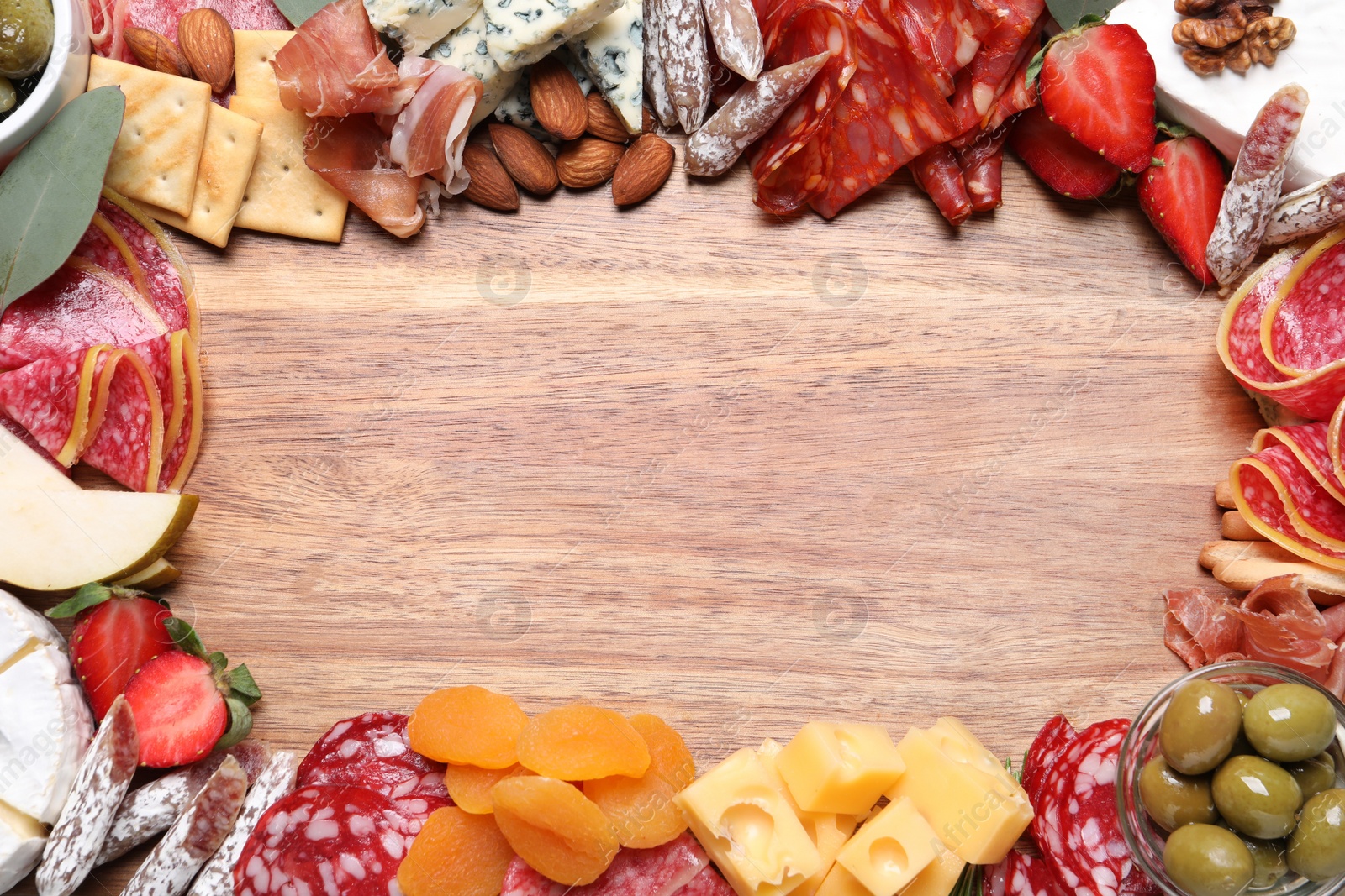 Photo of Frame of assorted appetizers on wooden background, flat lay. Space for text