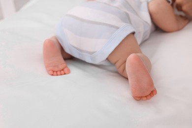 Photo of Newborn baby lying on white blanket, closeup