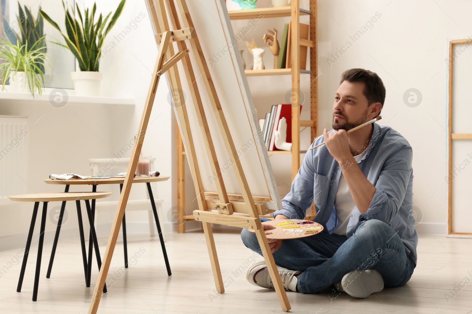 Photo of Handsome man painting in studio. Creative hobby