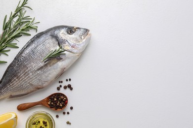 Photo of Flat lay composition with fresh raw dorado fish and ingredients on white table, space for text
