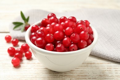 Photo of Tasty ripe cranberries on white wooden table, closeup