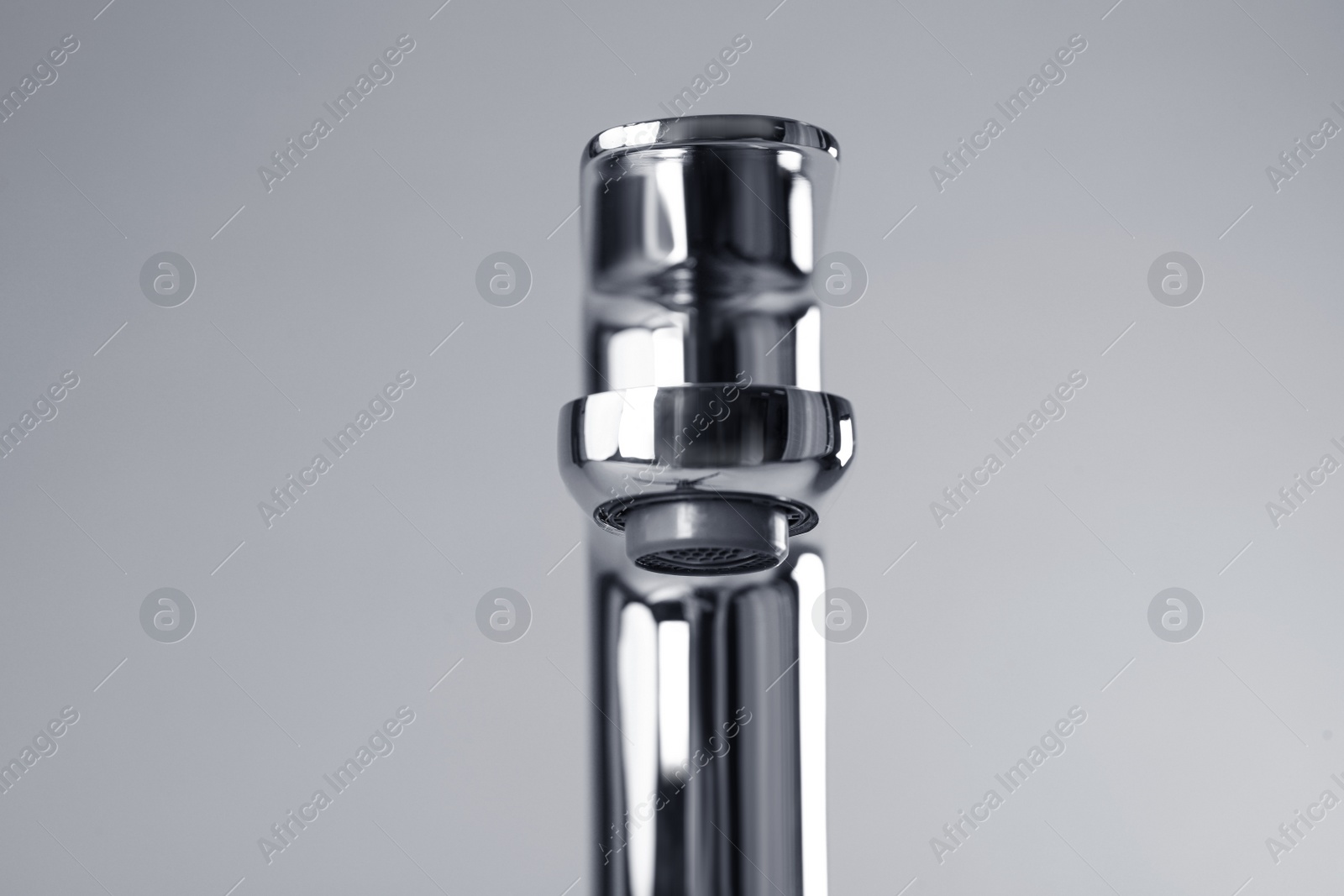 Photo of Single handle water tap on grey background, closeup