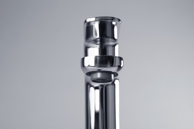 Photo of Single handle water tap on grey background, closeup