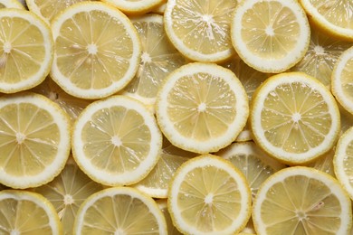 Photo of Slices of fresh lemons as background, top view